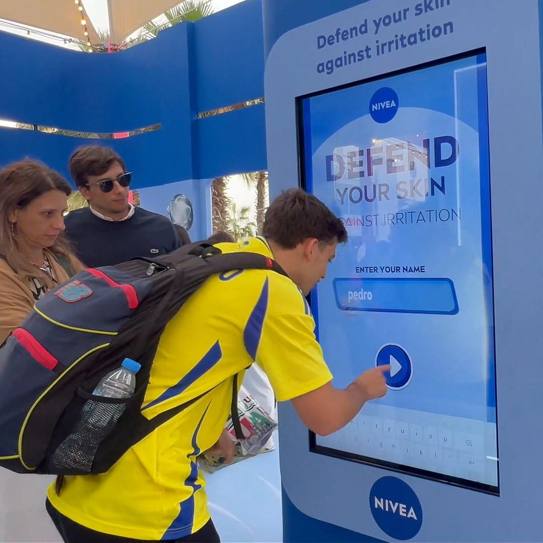 Guests playing the interactive Catch and Dodge game at a Niveae event in Dubai. Custom branded screen with data capture for exhibition marketing